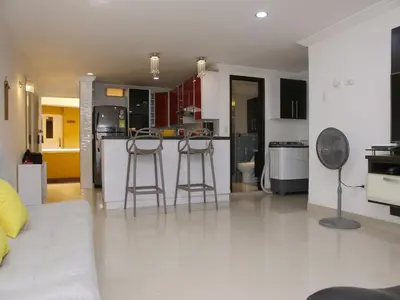 a kitchen with two bar stools in a living room at Historic Cartagena 2BR Apt in Cartagena de Indias