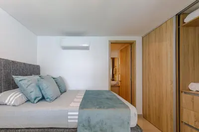 a bedroom with a bed with blue pillows at Cartagena Bella Por Días in Cartagena de Indias