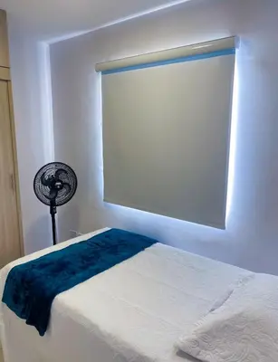 a room with a bed with a window and a fan at Hermoso apto, cerca al mar in Cartagena de Indias