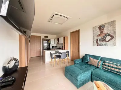 a living room with a blue couch and a kitchen at Apartamento con piscina, playa y cerca aeropuerto de Cartagena in Cartagena de Indias