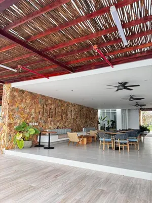 a lobby with a stone wall and tables and chairs at Apartamento con piscina, playa y cerca aeropuerto de Cartagena in Cartagena de Indias