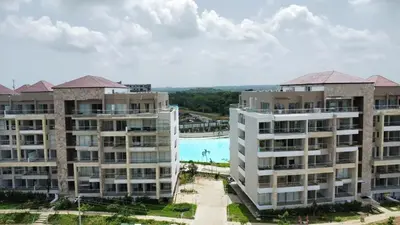 two apartment buildings with a pool in the background at Apartamento con piscina, playa y cerca aeropuerto de Cartagena in Cartagena de Indias