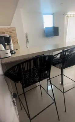 a kitchen counter with two black chairs at a table at Vista Lateral al Mar, ApartaEstudio , Cerca Hotel Hilton y Salida al Mar in Cartagena de Indias