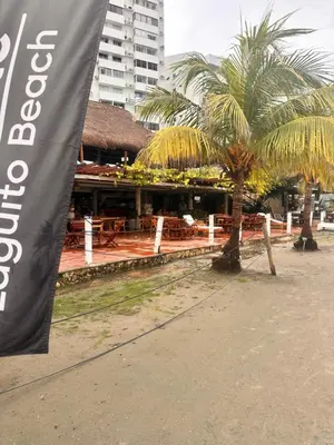 a flag is flying in front of a building with palm trees at Vista Lateral al Mar, ApartaEstudio , Cerca Hotel Hilton y Salida al Mar in Cartagena de Indias