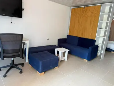 a living room with a couch and a desk and a chair at Club House in Maizal