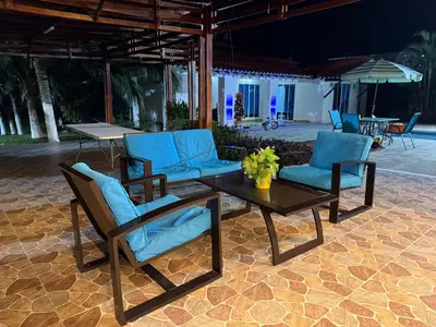 a patio with a table and blue chairs at Hacienda Villa Hermelina-Casa Campestre in Turbaco