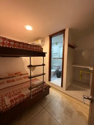 a bedroom with two bunk beds and a bathroom at Hostal El Recreo in Barranquilla