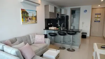 a living room with a couch and a kitchen at Palmetto Sunset in Cartagena de Indias