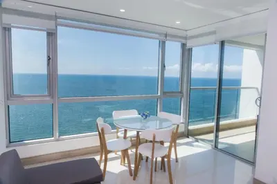 a dining room with a table and chairs and the ocean at Palmetto Sunset in Cartagena de Indias