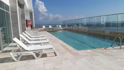 a row of lounge chairs next to a swimming pool on a building at Palmetto Sunset in Cartagena de Indias