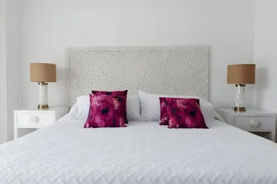 a white bed with two purple pillows on it at Elegante Apartamento en Cartagena con salida al Mar, Morros Epic in Cartagena de Indias