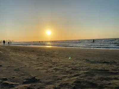 a sunset on a beach with people in the ocean at Elegante Apartamento en Cartagena con salida al Mar, Morros Epic in Cartagena de Indias