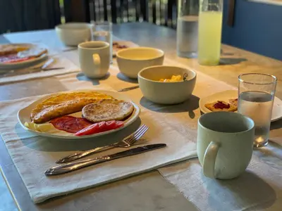 a table with a plate of food and a cup of milk at Serenity Home in San Bernardo del Viento