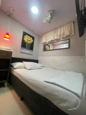 a bedroom with a bed with a vase of flowers on the wall at Vista Hermosa Portofino in Cartagena de Indias