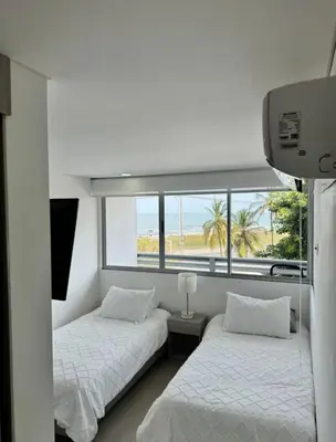 two beds in a room with a window at Hermoso apartamento moderno con vista al mar in Cartagena de Indias