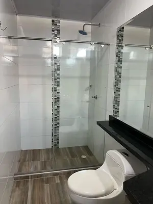 a bathroom with a toilet and a glass shower at Hotel Brisas in Tierra Bomba