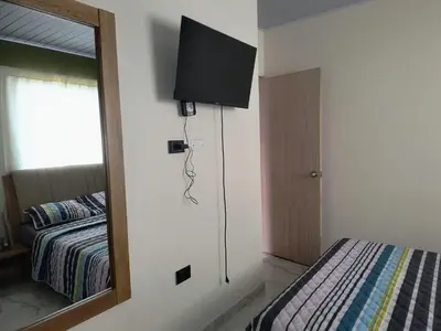 a bedroom with a tv on the wall and a bed at Cactus Beach Stay APARTAMENTO in Santa Marta