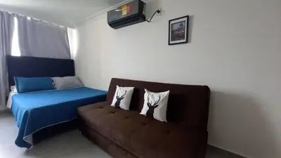 a room with a couch and a bed with pillows at PISO 12 Cerca a la playa, Piscina, Wifi, AC in Cartagena de Indias