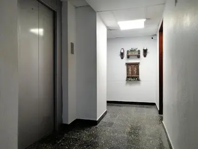 a hallway with a white wall with a window and a plant at PISO 12 Cerca a la playa, Piscina, Wifi, AC in Cartagena de Indias
