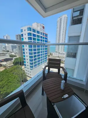 a balcony with a table and chairs and a view of a city at Bocagrande Urban loft in Cartagena de Indias