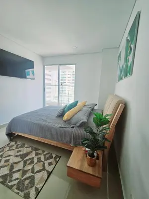 a bedroom with a bed and a potted plant at Bocagrande Urban loft in Cartagena de Indias