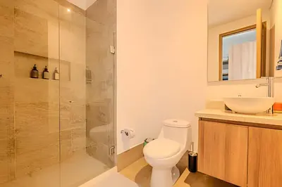 a bathroom with a toilet and a glass shower at Nuevo Vista al Mar / Centro Histórico Piso 28 in Cartagena de Indias
