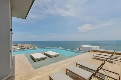 a swimming pool with chairs and a view of the ocean at Nuevo Vista al Mar / Centro Histórico Piso 28 in Cartagena de Indias