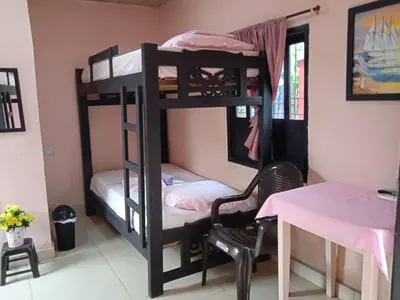 a room with two bunk beds with a table and a desk at Hotel Doña Edita in San Bernardo del Viento