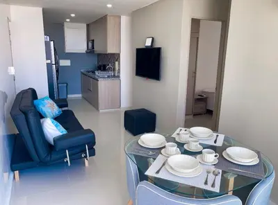 a living room with a glass table and a chair at Espectacular vista a la Ciudad in Cartagena de Indias
