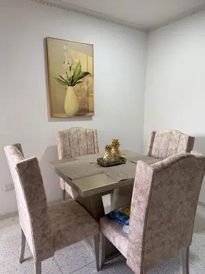 a dining room table with two chairs and a painting at Apartamento central en Barranquilla in Barranquilla