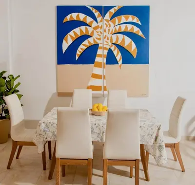 a dining room with a table and chairs and a palm tree at Apartamento Benitez 301 by Zakher in Cartagena de Indias