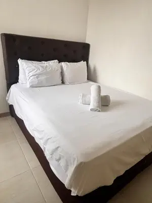 a bed with white sheets and two towels on it at Cómodo y Comfortable Apto in Cartagena de Indias