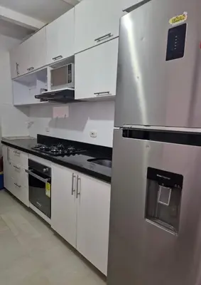 a kitchen with a stainless steel refrigerator and white cabinets at Cómodo y Comfortable Apto in Cartagena de Indias