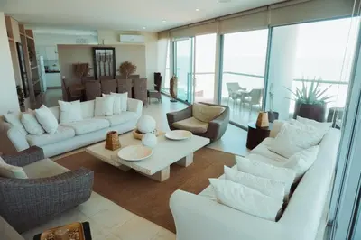 a living room with white furniture and large windows at SeaWay Apartamento 5 Habitaciones para 12 Personas in Cartagena de Indias