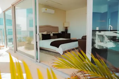a bedroom with a bed and sliding glass doors at SeaWay Apartamento 5 Habitaciones para 12 Personas in Cartagena de Indias