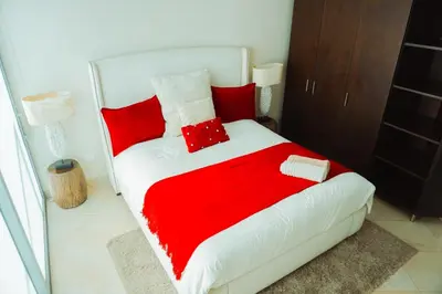 a red and white bed with red pillows on it at SeaWay Apartamento 5 Habitaciones para 12 Personas in Cartagena de Indias