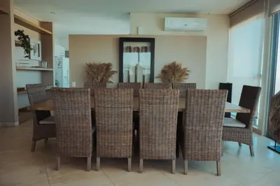 a dining room with a table and wicker chairs at SeaWay Apartamento 5 Habitaciones para 12 Personas in Cartagena de Indias