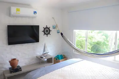 a bedroom with a bed and a tv on the wall at Serenity by the Sea in Juan de Acosta