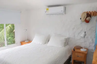 a bedroom with a white bed and a window at Serenity by the Sea in Juan de Acosta