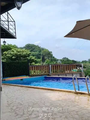 a swimming pool at a resort with an umbrella at Arumake in Turbaco