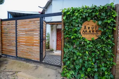 a wooden sign on a fence with a bush at Arumake in Turbaco