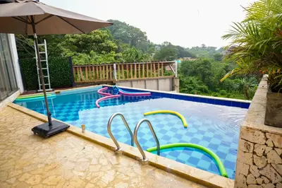 a swimming pool with an umbrella and a swimming pool at Arumake in Turbaco