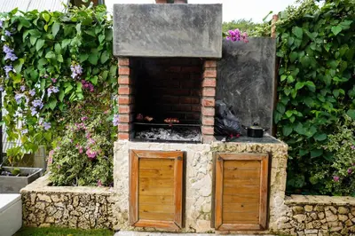 a stone oven with two doors in a garden at Arumake in Turbaco
