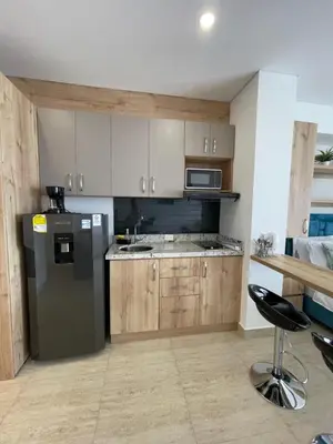 a kitchen with wooden cabinets and a stainless steel refrigerator at Crespo Horizon Suite in Cartagena de Indias