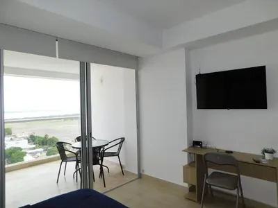 a dining room with a table and a television on the wall at Crespo Horizon Suite in Cartagena de Indias