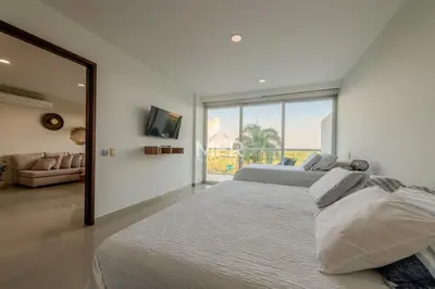 a white bedroom with two beds and a large window at Edificio Morros Vitri, 2 Bedrooms- Comfy Apartment in Cartagena de Indias