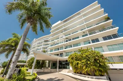 a large white building with palm trees in front of it at Edificio Morros Vitri, 2 Bedrooms- Comfy Apartment in Cartagena de Indias