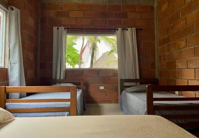 a bedroom with two beds and a brick wall at Playa del Toro in El Bobo