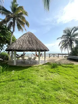 a gazebo on the beach with palm trees and the ocean at Playa del Toro in El Bobo