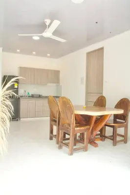 a kitchen with a wooden table and chairs at Cabañas El Laguito Coveñas in Coveñas